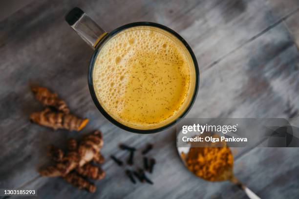 turmeric latte drink close-up top view. turmeric root and powder. superfood concept, healthy food lifehack. - chai tea stock pictures, royalty-free photos & images