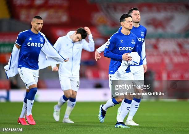 James Rodriguez, Richarlison and Michael Keane of Everton remove their tracksuit toops ahead of the Premier League match between Liverpool and...