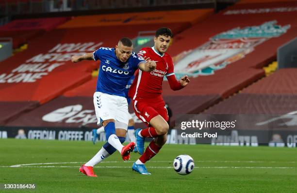 Richarlison of Everton scores his team's first goal whilst under pressure from Ozan Kabak of Liverpool during the Premier League match between...