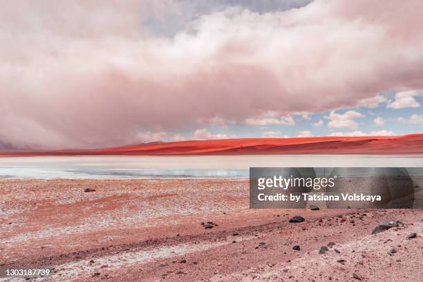 red volcanic mountains reflection in the lake - antofagasta region stock-fotos und bilder