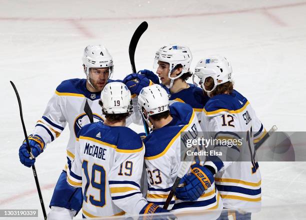 Colin Miller of the Buffalo Sabres is congratulated by teammates Taylor Hall,Jake McCabe,Dylan Cozens and Eric Staal after Miller scored in the first...