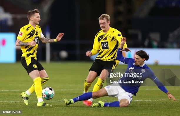 Julian Brandt of Borussia Dortmund is challenged by Benjamin Stambouli of FC Schalke 04 during the Bundesliga match between FC Schalke 04 and...