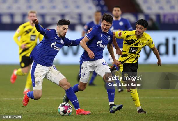 Suat Serdar of FC Schalke 04 and Alessandro Schoepf of FC Schalke 04 hold off Mahmoud Dahoud of Borussia Dortmund during the Bundesliga match between...