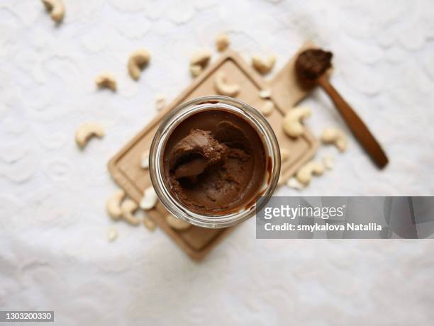 nut chocolate paste on a white background top view. chocolate butter, chocolate cashews paste. - nut butter stock pictures, royalty-free photos & images