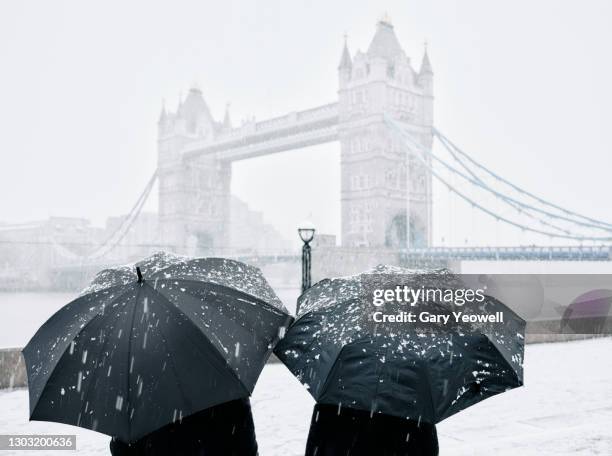 tourists by tower bridge in snow - escapade urbaine photos et images de collection