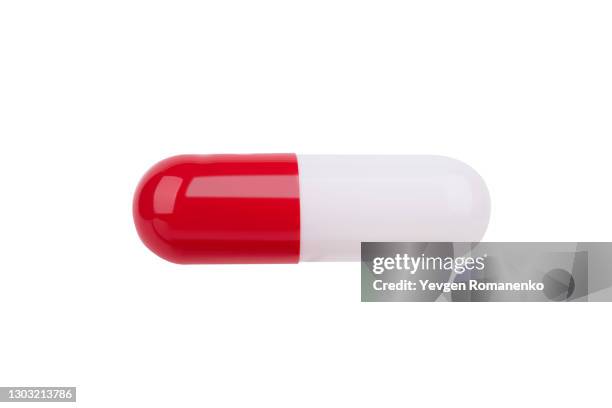 red and white gelatine pill isolated on white background - antibiotic pills stock pictures, royalty-free photos & images