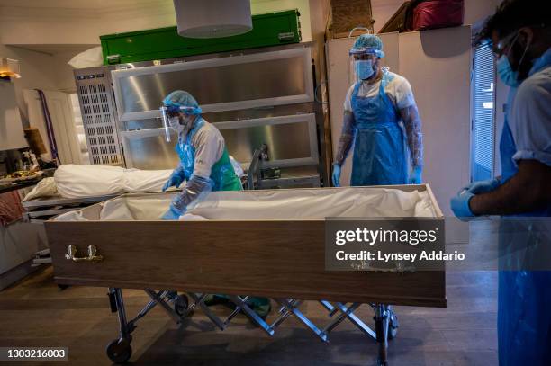 Islamic funeral director Mohammed Tariq and his assistant, Zain Muhammed bin Farooq tends the body of man who passed away with COVID-19 after the...