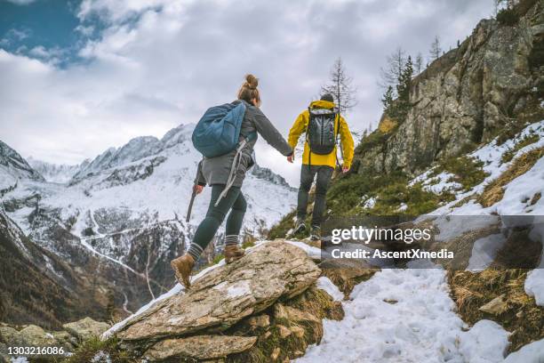 young couple of hikers bound up ridge together - climbing snow mountain imagens e fotografias de stock