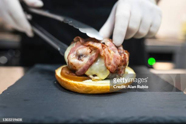 professional chef cooking the perfect burger in a new kitchen. - chef rubio stock pictures, royalty-free photos & images