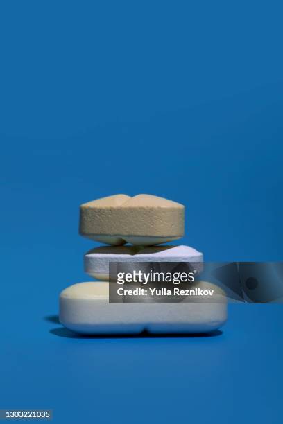stack of various pills and tablets on the blue background - antibiotics stock pictures, royalty-free photos & images