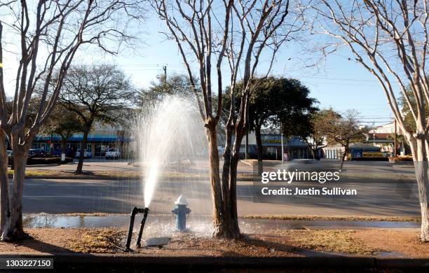 Water shoots out of a burst pipe outside of a restaurant on February 20, 2021 in Houston, Texas. Much of Texas is still struggling with historic cold...