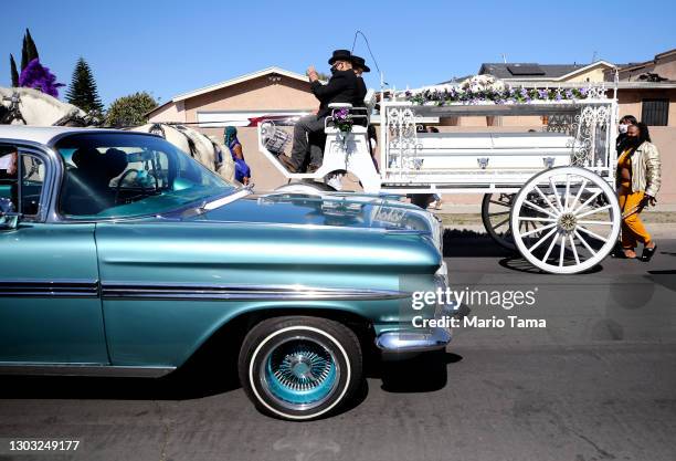 People follow the horse-drawn hearse funeral procession for Gilbert Lee Miller Sr. Through the historic community of Watts amid the pandemic on...