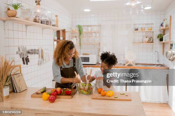 girl learning to prepare meal from mother - salad bowl stock pictures, royalty-free photos & images