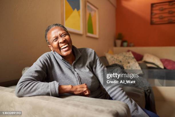 laughing senior woman at home - simple living room only stock pictures, royalty-free photos & images
