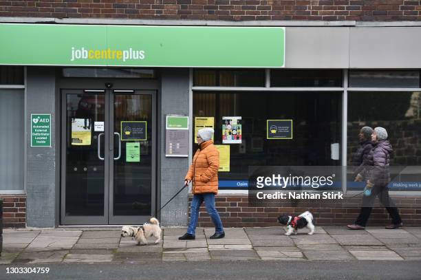 People walk their dogs past a Jobcentre employment office on February 21, 2021 in Tunstall, England.
