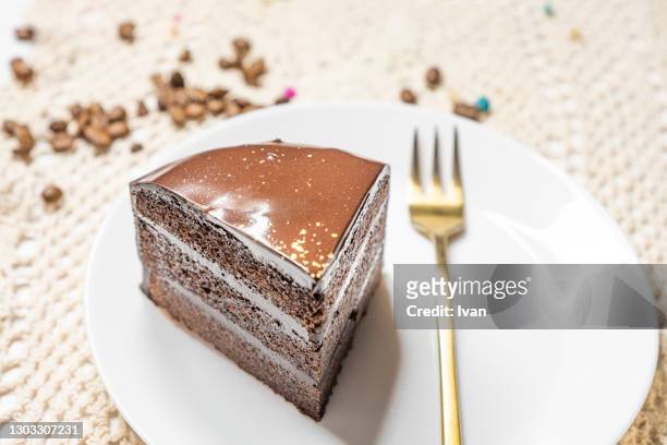 piece of chocolate sachertorte cake on table with decoration - sachertorte stock-fotos und bilder