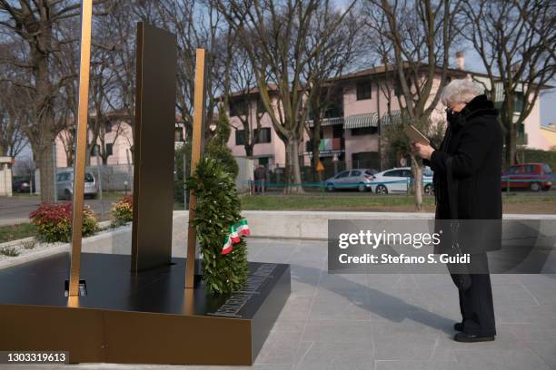 Woman wearing aprotective mask looks at the memorial for the victims of coronavirus on February 21, 2021 in Codogno, Italy. A memorial for the...