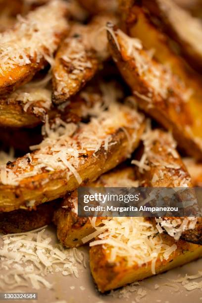 close-up of roasted potato slices served with parmesan cheese - bratkartoffel stock-fotos und bilder