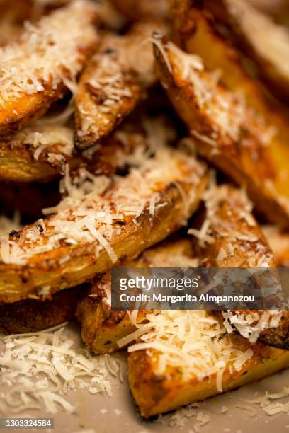 close-up of roasted potato slices served with parmesan cheese - fried potato stock pictures, royalty-free photos & images