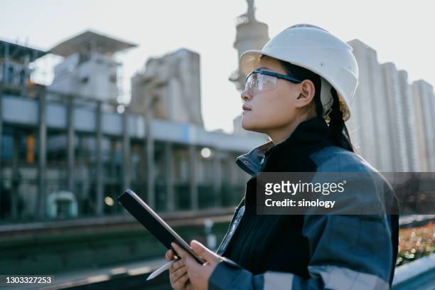 asian female engineer working in factory with tablet - mechanic tablet stock-fotos und bilder
