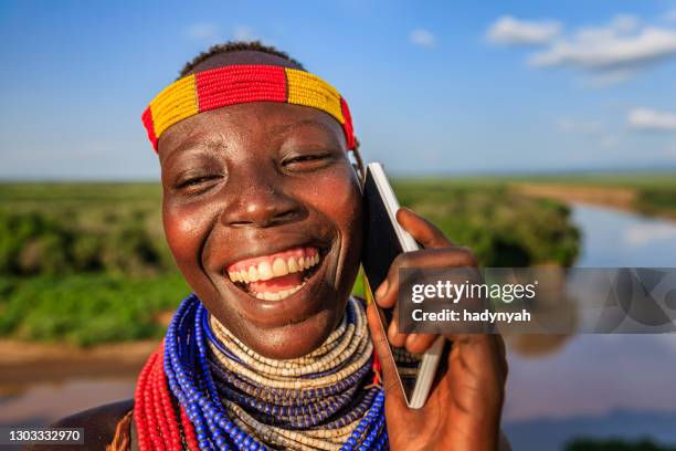 來自非洲衣索比亞卡羅部落的年輕女孩使用智能手機 - african tribal face painting 個照片及圖片檔