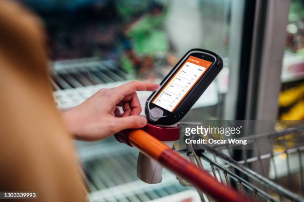 grocery shopping with a smart handset - selbstbedienung stock-fotos und bilder