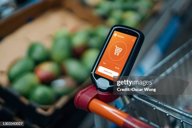 grocery shopping with a smart handset - visual merchandise stock pictures, royalty-free photos & images