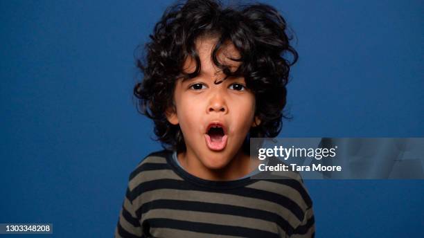 young boy shouting with blue background - surprise face kid stock-fotos und bilder