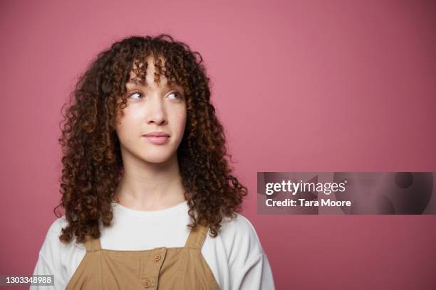 young woman glancing sideways - sideways glance - fotografias e filmes do acervo