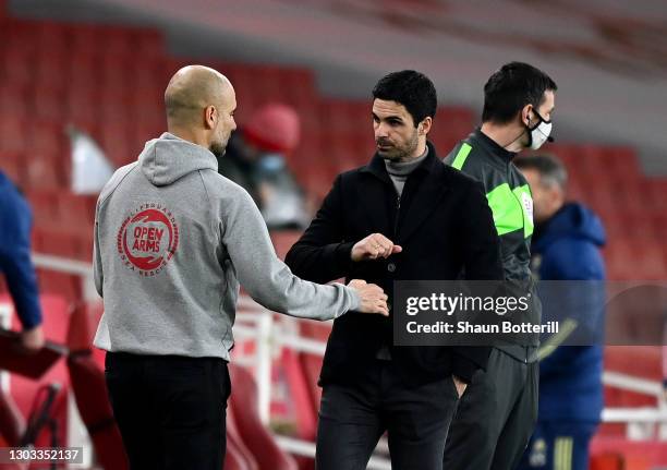 Pep Guardiola, Manager of Manchester City bumps fists with Mikel Arteta, Manager of Arsenal after the Premier League match between Arsenal and...