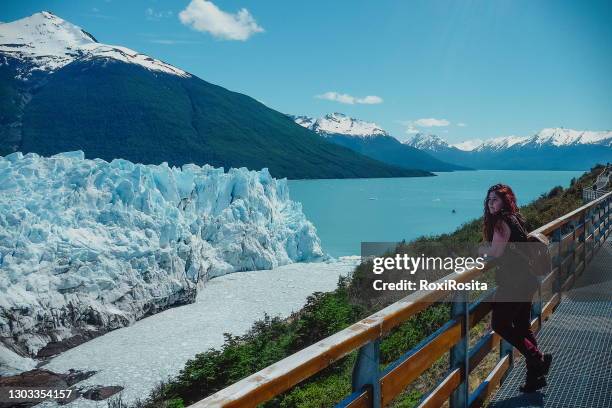 a tourist is standing in front of the perito moreno glacier, los glaciares national park in the province of santa cruz, argentina - エルカラファテ ストックフォトと画像