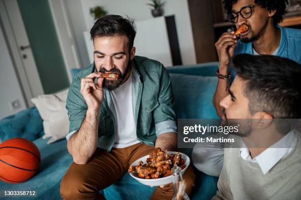 friends at home eating fast food - wings stock pictures, royalty-free photos & images