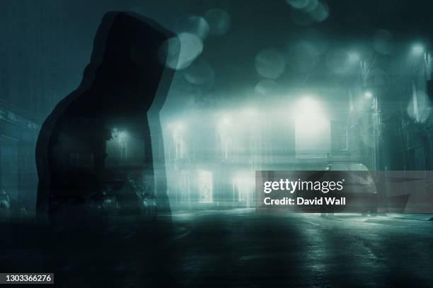 a double exposure concept of a hooded man on a road in a town silhouetted by lights on a misty winters night. with a abstract, vintage edit. - crime in the uk stock pictures, royalty-free photos & images