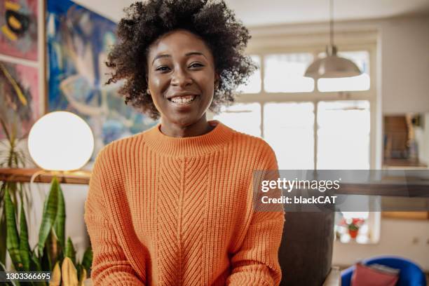 porträt von lächelnden afroamerikanischen jungen frau drinnen im gespräch mit der kamera, videoanruf, aufnahme vlog - camera woman stock-fotos und bilder