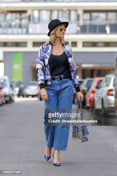 German TV host Carola Ferstl wearing a blue, black and white bomber jacket with floral print by Nanna Kuckuck, blue pumps by Jean-Michel Cazabat, a...