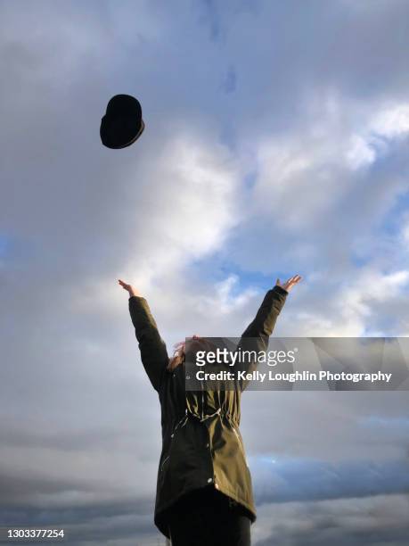 girl throwing hat in air - mogelijk stockfoto's en -beelden