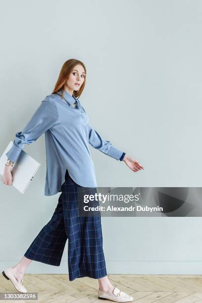 woman in casual clothes is walking with laptop - standing with laptop imagens e fotografias de stock