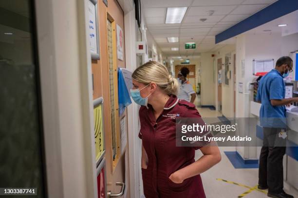 Healthcare Emily Birch peeking through door to check on the COVID-19 patient in the A&E at the University Hospital Coventry on May 25, 2020 in...