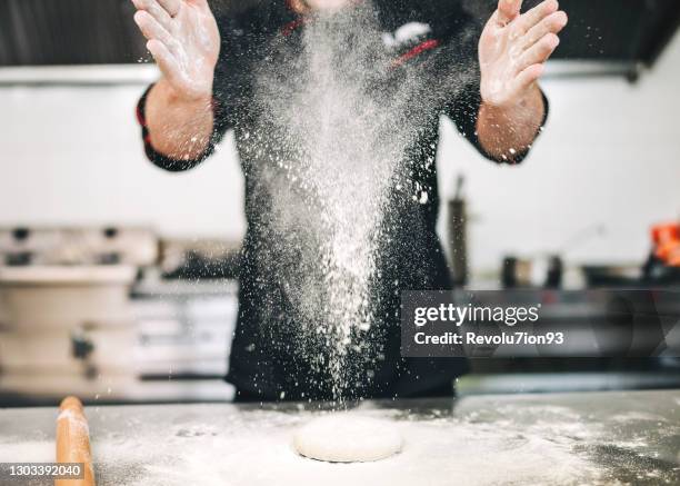 männlicher küchenchef bereitet eine pizza in der küche zu - bäcker stock-fotos und bilder