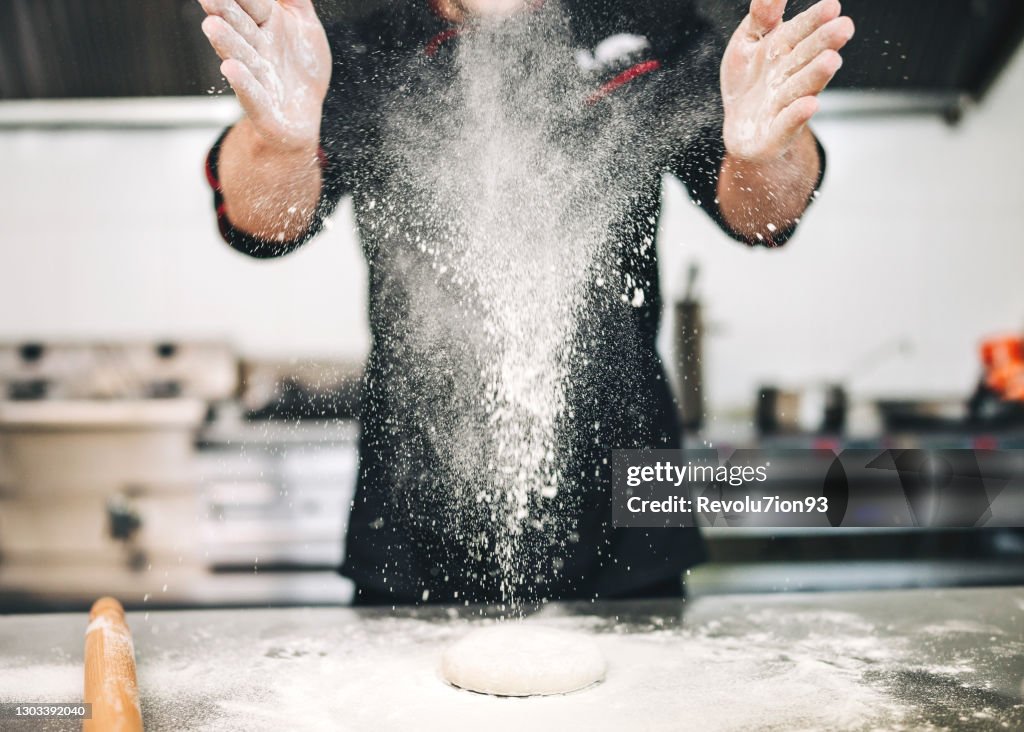 Male Chef preparing a pizza in the kitchen