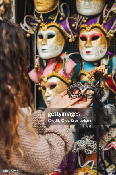 woman hands close-up holding venetian mask on italian market. traditional souvenir from venice - fiesta posterior stock pictures, royalty-free photos & images