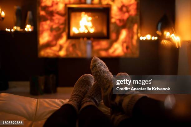 feet in wool socks near fireplace in winter time. - cosy stockfoto's en -beelden