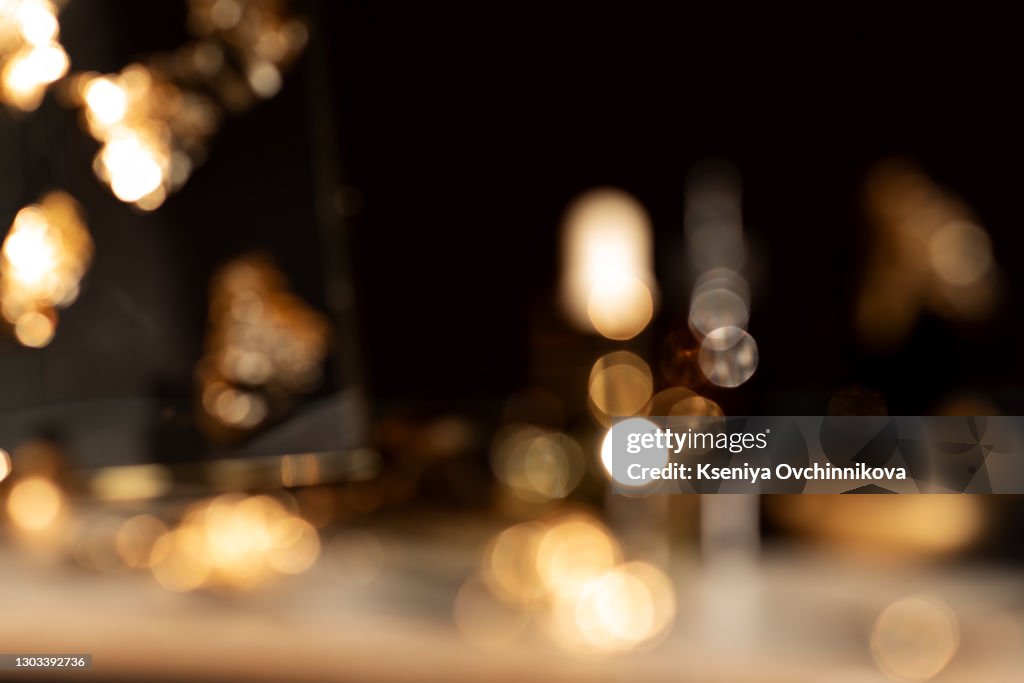 Image of wooden table in front of abstract blurred background of resturant lights