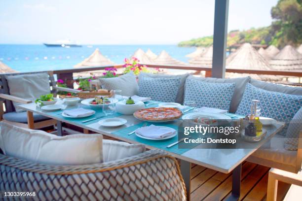 summmertime dinner tables near the sea - waterfront dining stock pictures, royalty-free photos & images