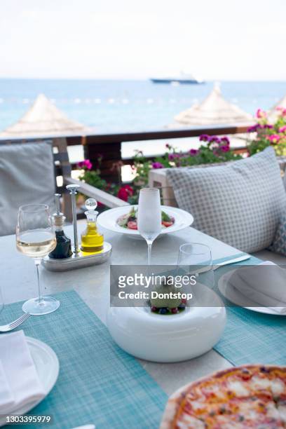 summmertime dinner tables near the sea - waterfront dining stock pictures, royalty-free photos & images
