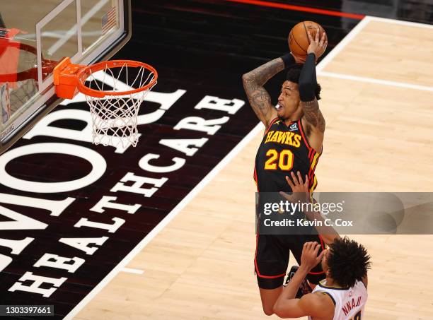 John Collins of the Atlanta Hawks catches an alley-oop for a dunk against Zeke Nnaji of the Denver Nuggets during the first half at State Farm Arena...