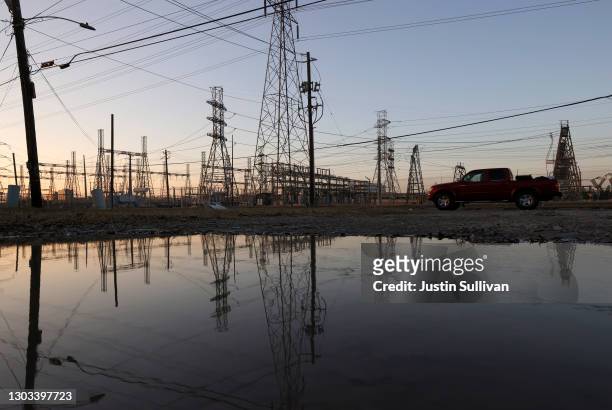 An electrical substation is reflected in water on February 21, 2021 in Houston, Texas. Millions of Texans lost their power when winter storm Uri hit...