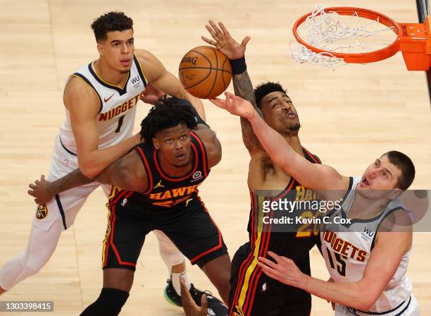 John Collins of the Atlanta Hawks blocks a shot by Nikola Jokic of the Denver Nuggets during the first half at State Farm Arena on February 21, 2021...