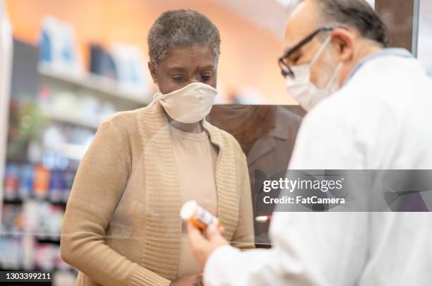 african woman wearing a mask at the pharmacy stock photo - pharmacy mask stock pictures, royalty-free photos & images