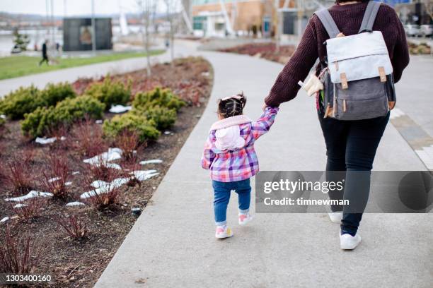 spaanse moeder en babydochter die bij het park lopen - diaper bag stockfoto's en -beelden